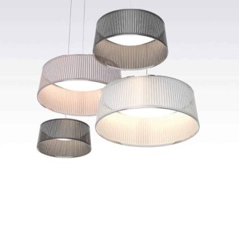 Four Solis Drum pendant lights with cylindrical mesh shades hang at varying heights against a white background.