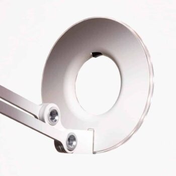Close-up of the Link Clamp, a modern circular desk lamp with an open center, attached to a metallic adjustable arm on a white background.