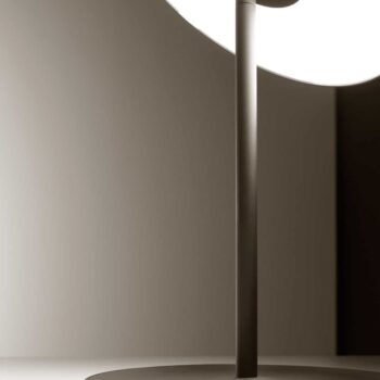 Close-up of the Circa Floor lamp featuring a modern design with a round base and slim pole, illuminated in soft lighting.
