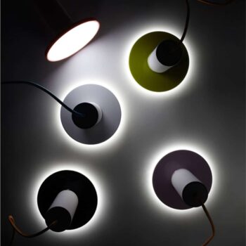 The Cielo Pendant lights elegantly hover with their five cylindrical shapes, casting a soft glow against a dark background.