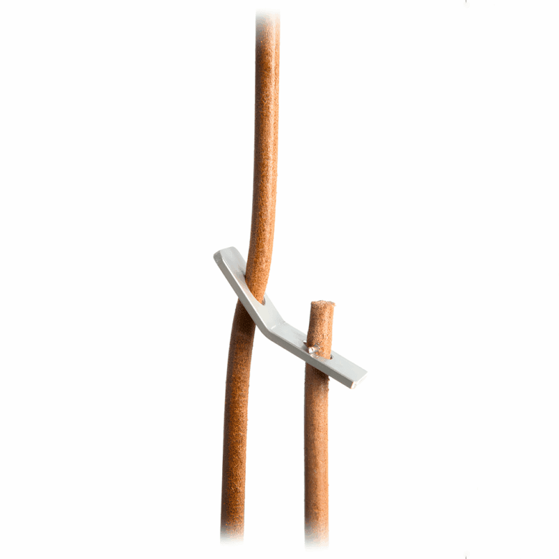 A metal blade is wedged between two brown sticks, with one stick partially cut and separated from the other, creating a sense of warmth and ambience reminiscent of lighting for autumn.