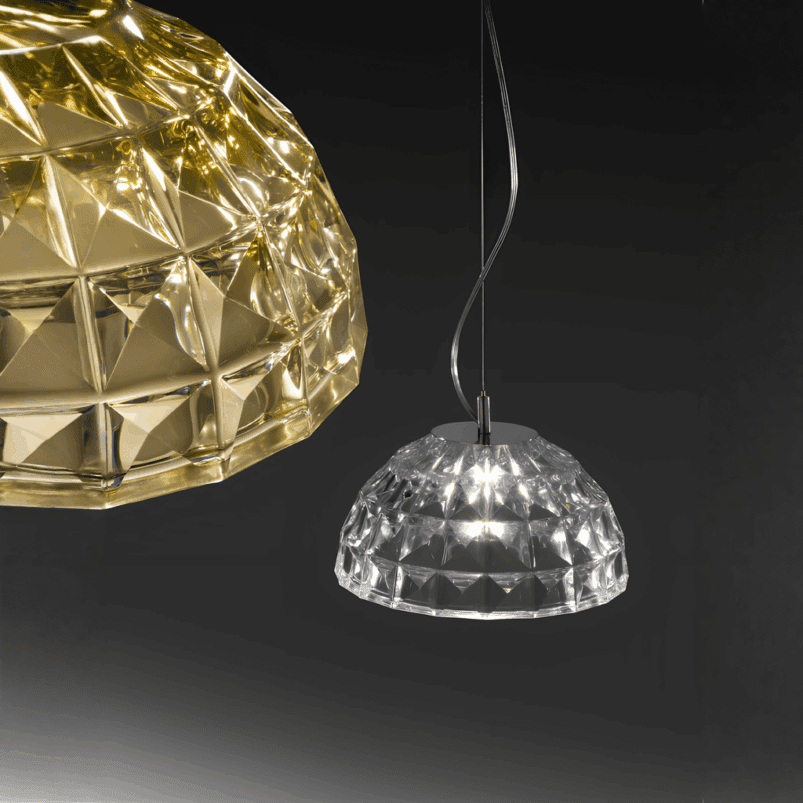 Two dome-shaped pendant lights with a geometric, faceted design create a warm ambience against a dark background—one in gold, the other in clear—perfect lighting for autumn evenings.