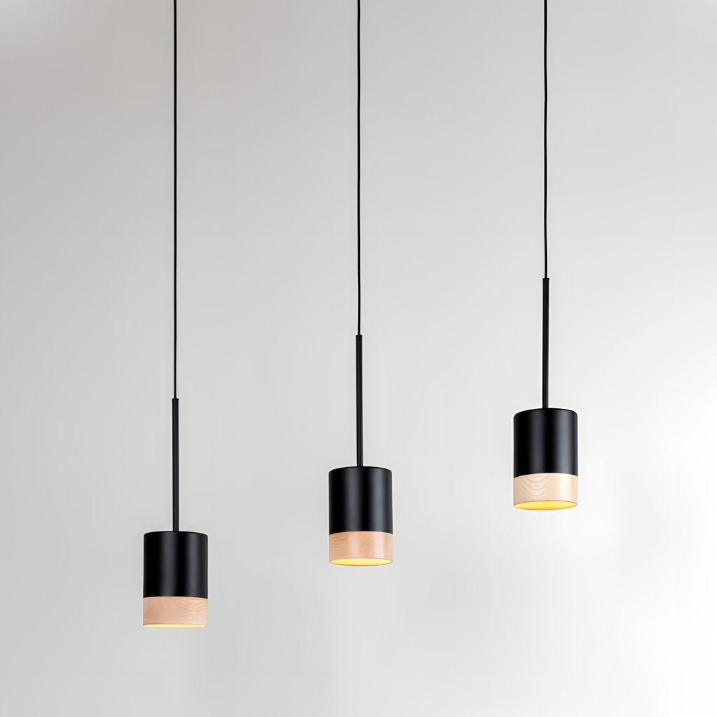 Three modern black pendant lights with exposed bulbs hang from the ceiling against a plain white background, creating inviting ambience and warmth—ideal lighting for autumn evenings.