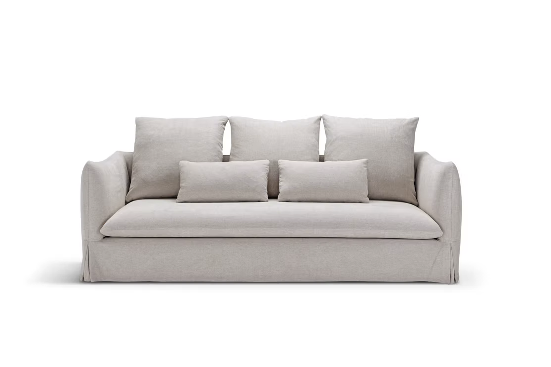 The Dylan Sofa is a beige couch featuring three large back cushions and two smaller rectangular cushions, shown against a white background.