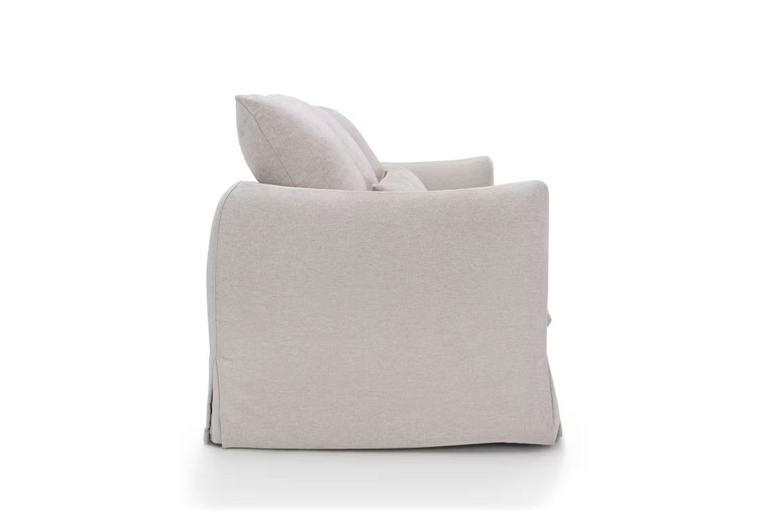 Side view of the Dylan Sofa in light beige upholstery, featuring two large back cushions and rounded armrests, displayed against a plain white background.
