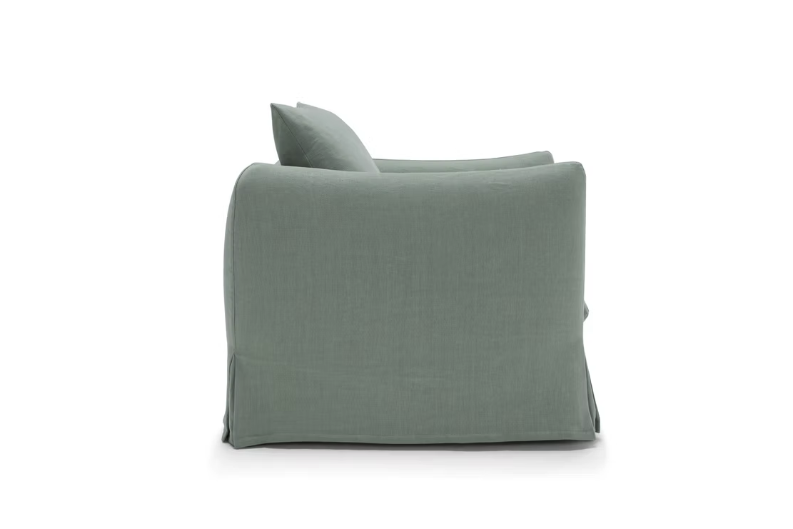 Side view of the Dylan Sofa, featuring light green upholstery with a loose cover, set against a plain white background.