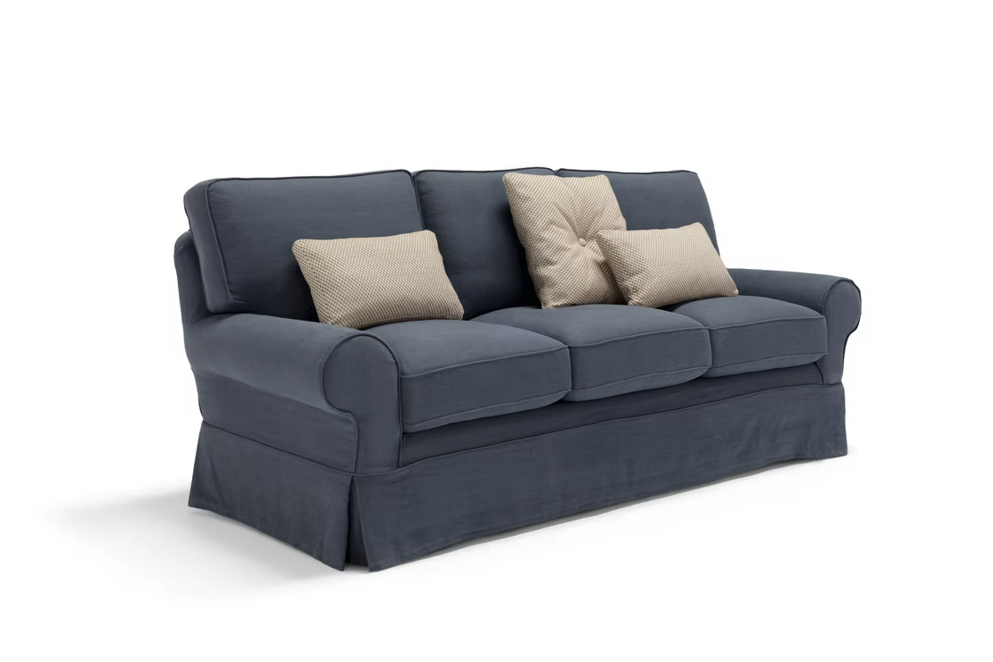 The Pantelleria Sofa is a blue upholstered three-seater with three seat cushions and three beige throw pillows, displayed against a white background.